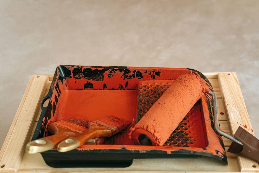 Paint Roller and Brushes with Brown Paint on Plastic Tray
